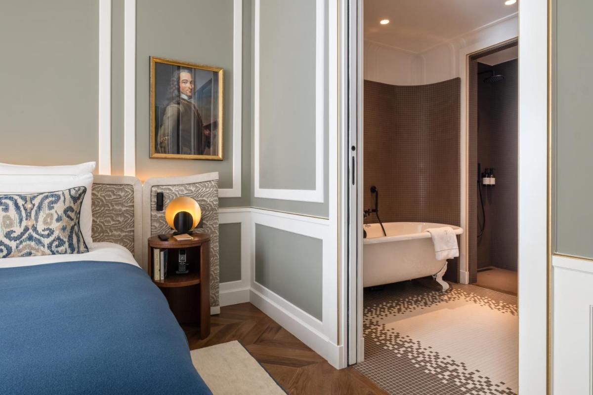 Un ou plusieurs lits dans un hébergement de l'établissement Hôtel Les Lumières - Relais & Châteaux