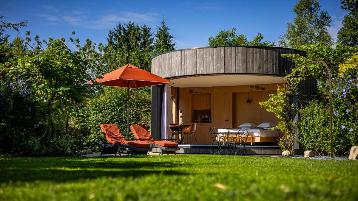 une maison circulaire avec un parapluie orange dans une cour dans l'établissement Château de Courban and Spa Nuxe, à Courban