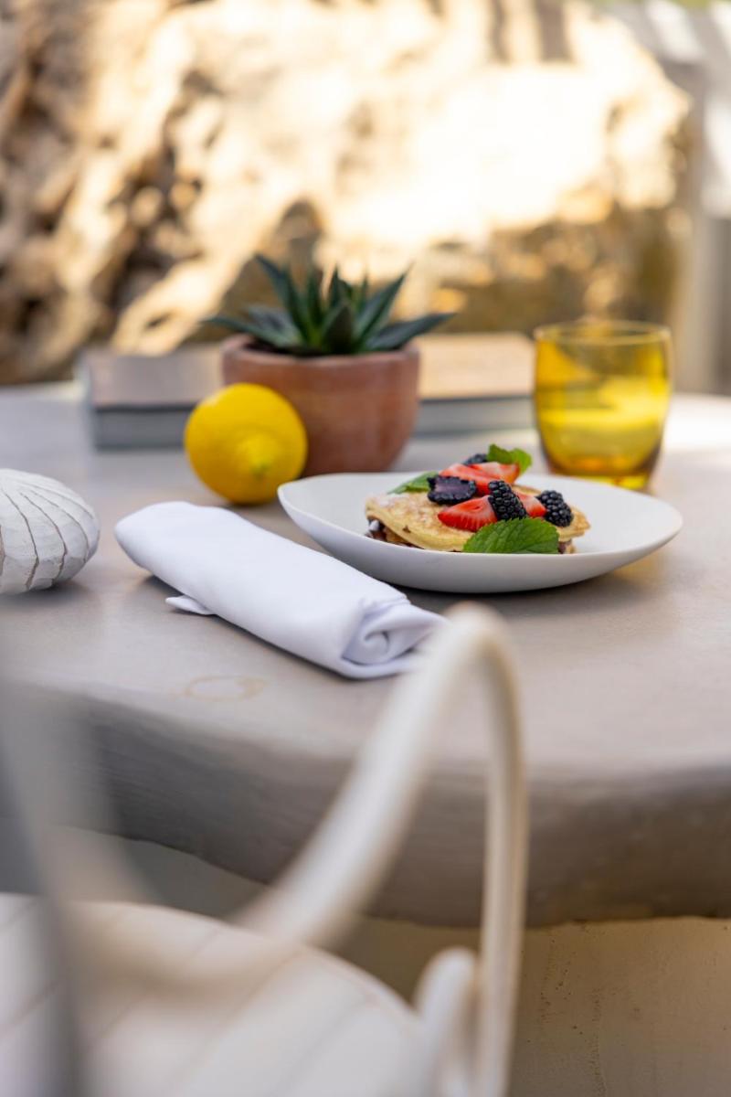 Un plato de comida con fruta en una mesa. en Hacienda Na Xamena, Ibiza, en Na Xamena