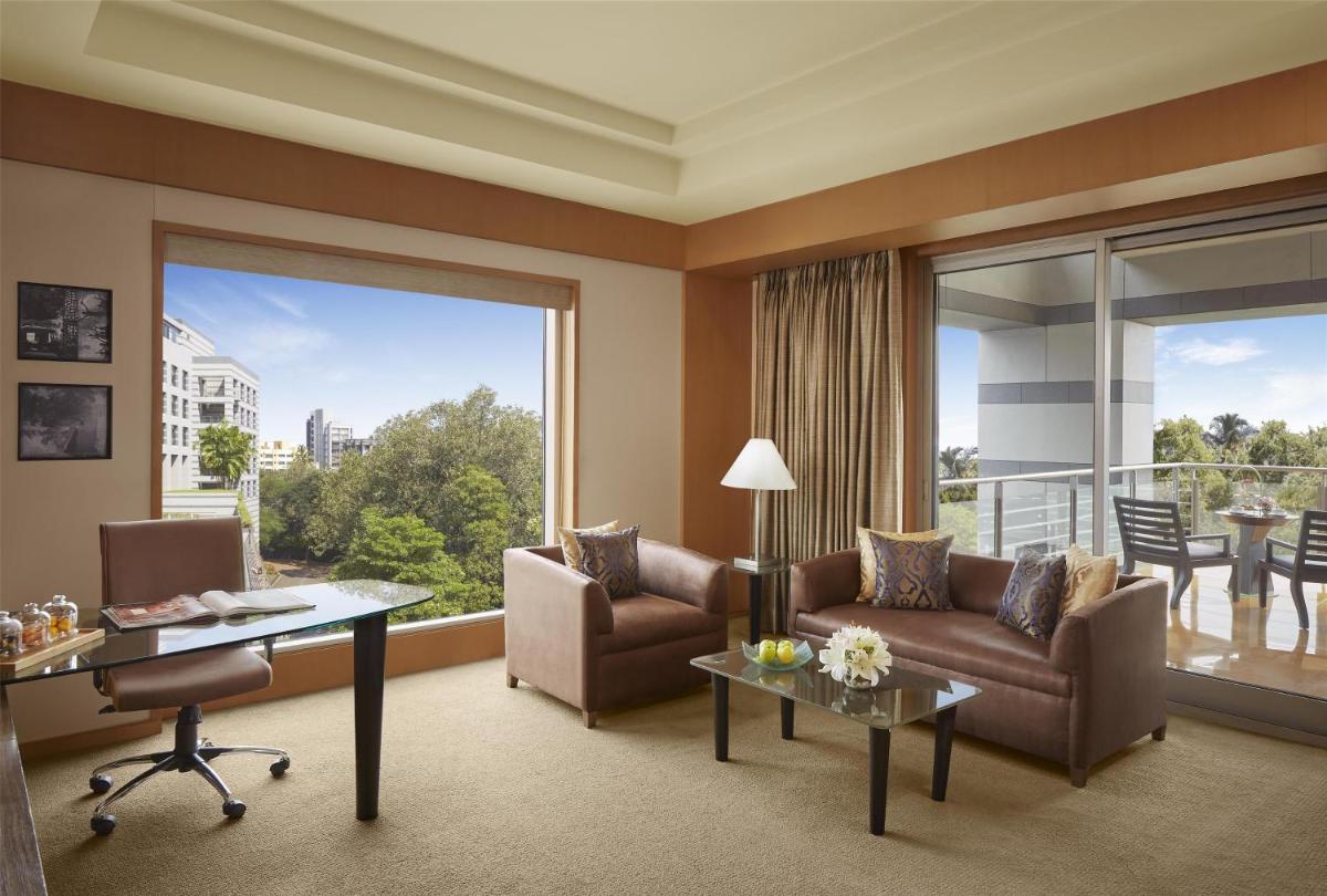 a living room with a couch and a table at Grand Hyatt Mumbai Hotel and Residences in Mumbai
