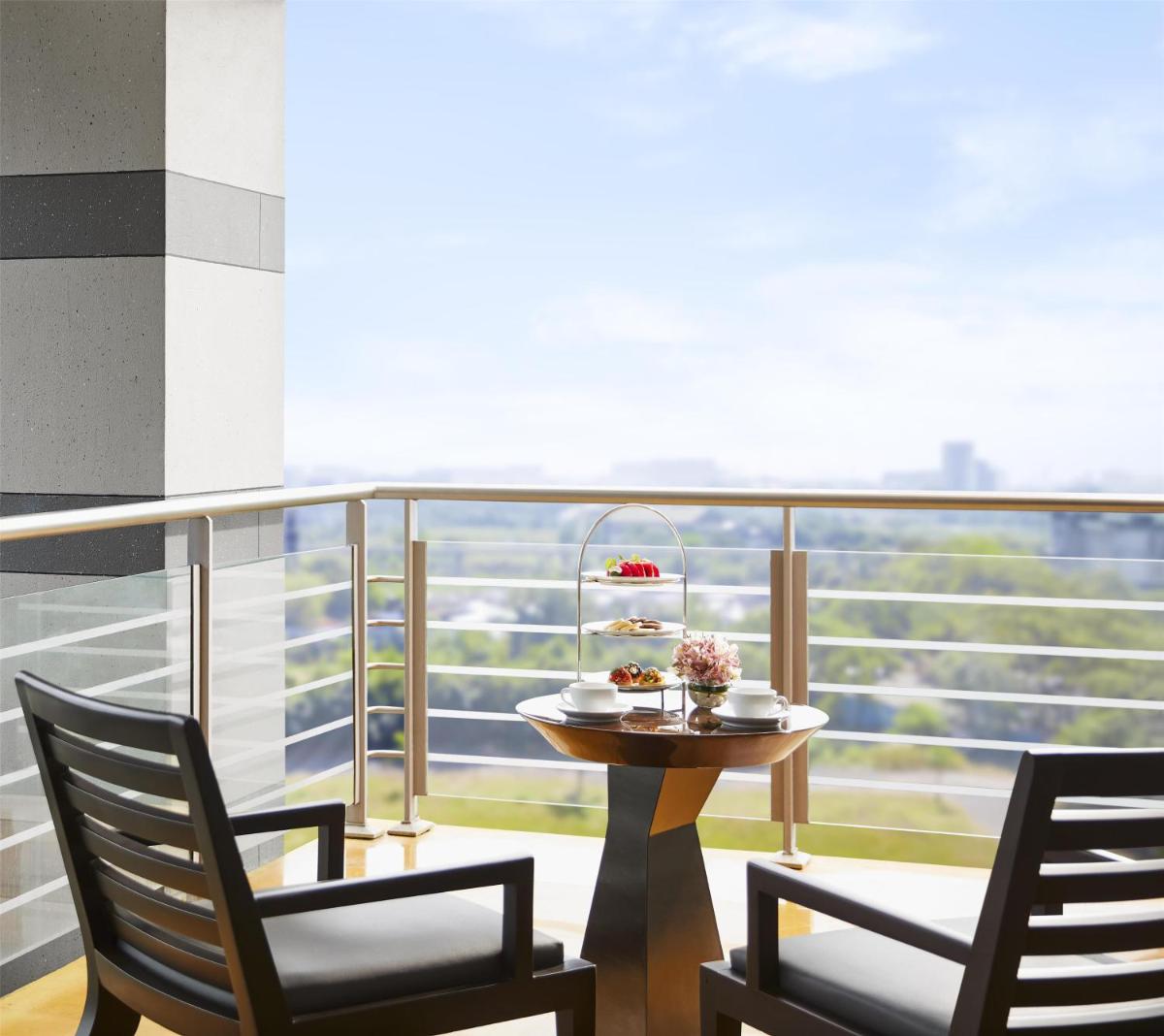 a table and two chairs on a balcony at Grand Hyatt Mumbai Hotel and Residences in Mumbai