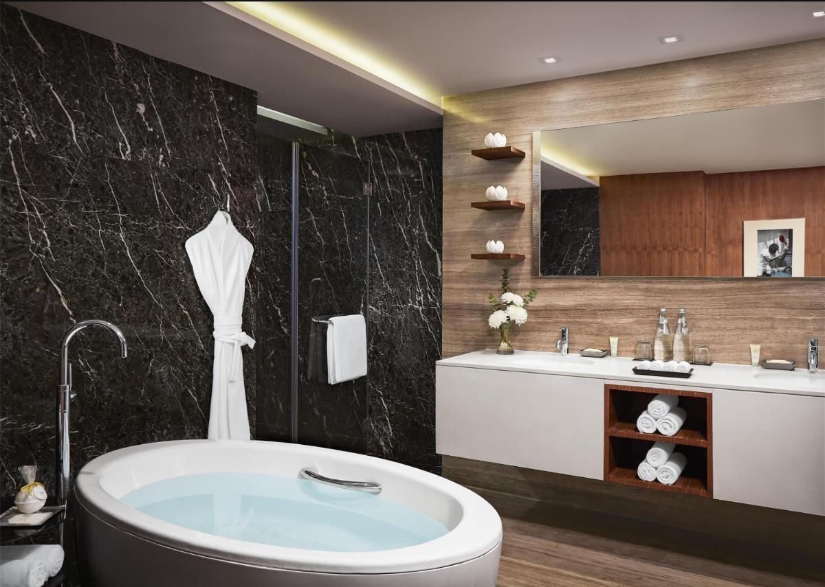 a bathroom with a tub and a sink at Grand Hyatt Mumbai Hotel and Residences in Mumbai