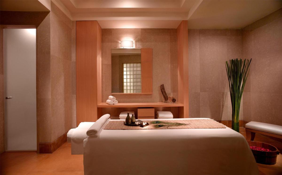 a hotel room with a bed and a mirror at Grand Hyatt Mumbai Hotel and Residences in Mumbai