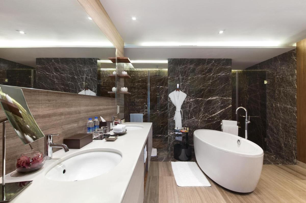 a bathroom with two sinks and a bath tub at Grand Hyatt Mumbai Hotel and Residences in Mumbai