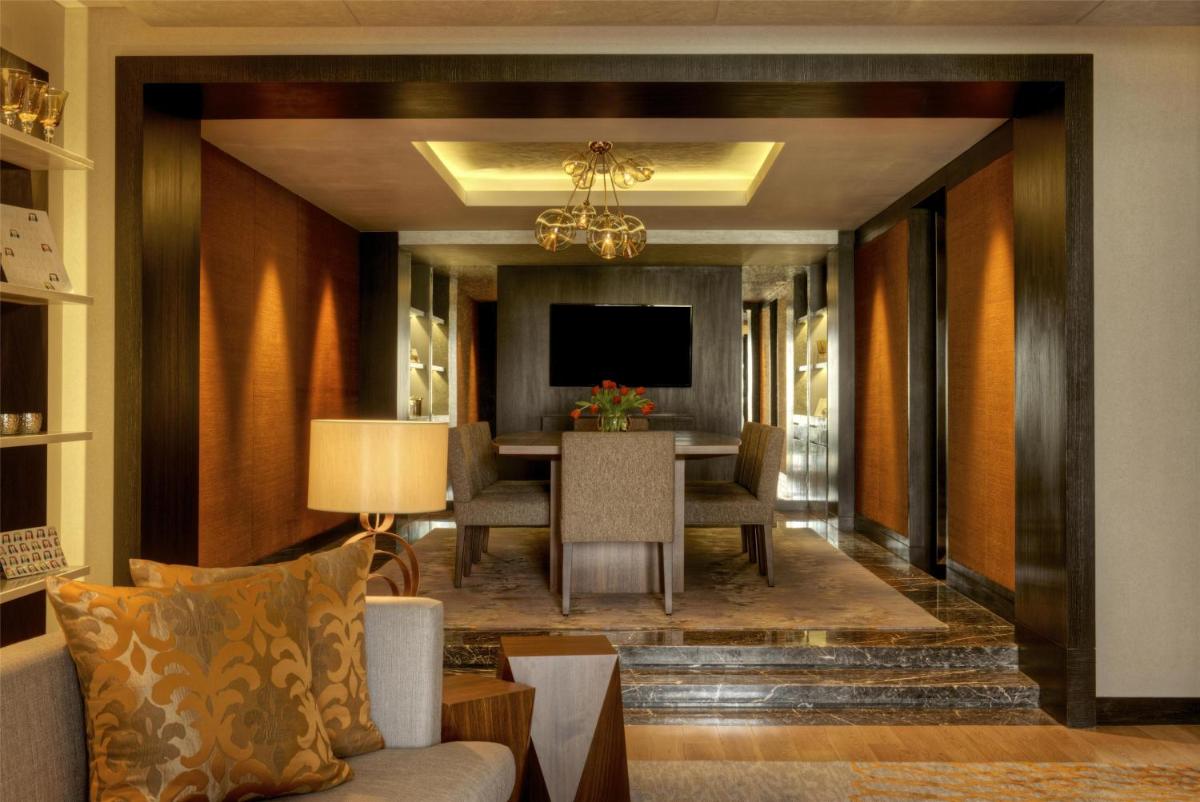 a living room with a table and a television at Grand Hyatt Mumbai Hotel and Residences in Mumbai