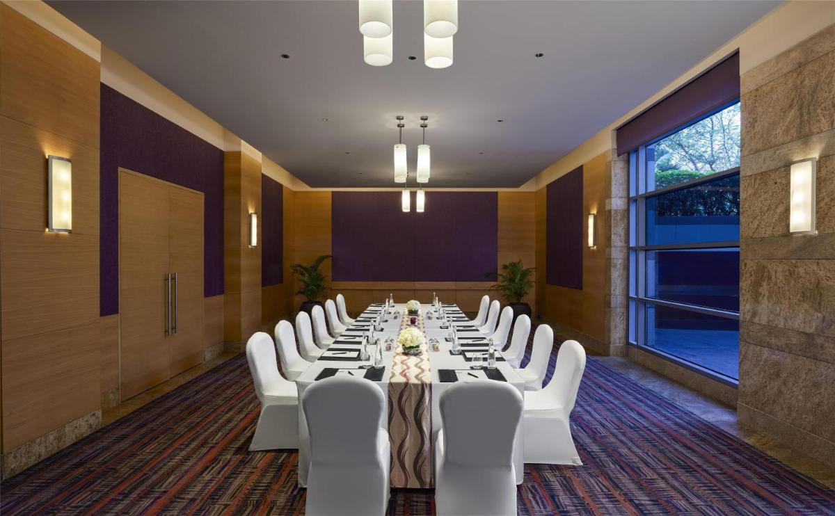 a conference room with a long table and white chairs at Grand Hyatt Mumbai Hotel and Residences in Mumbai