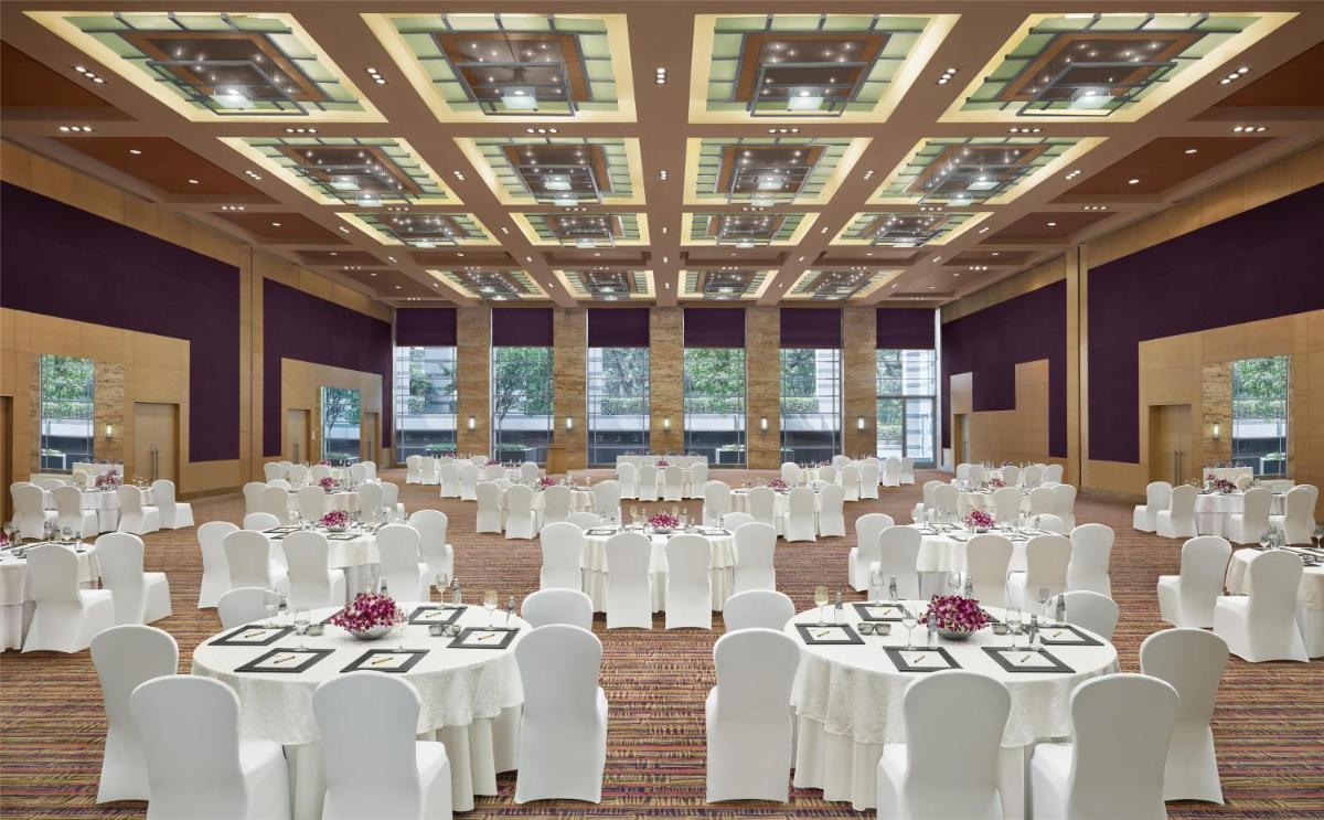 a banquet hall with white tables and white chairs at Grand Hyatt Mumbai Hotel and Residences in Mumbai
