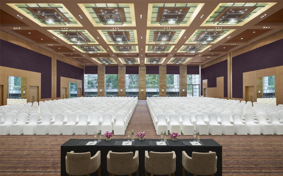 a large room with white chairs and tables in it at Grand Hyatt Mumbai Hotel and Residences in Mumbai