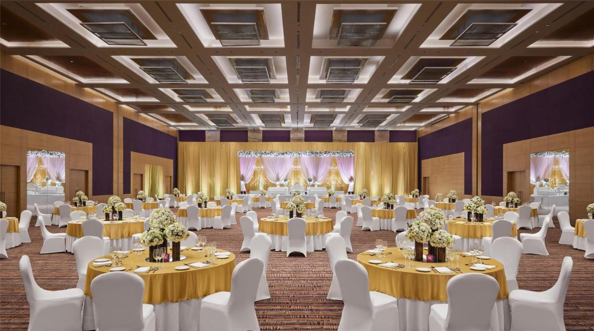 a banquet hall with tables and white chairs at Grand Hyatt Mumbai Hotel and Residences in Mumbai