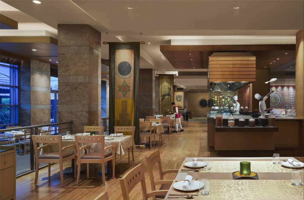 a dining room with tables and chairs in a restaurant at Grand Hyatt Mumbai Hotel and Residences in Mumbai