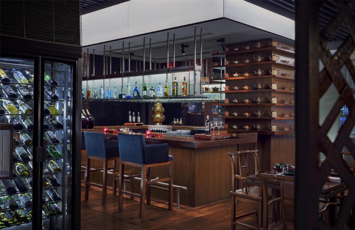 a bar in a restaurant with blue bar stools at Grand Hyatt Mumbai Hotel and Residences in Mumbai