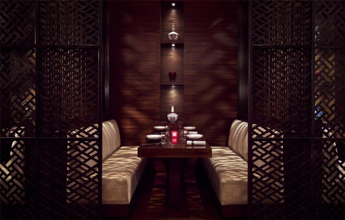 a dining room with a table and two chairs at Grand Hyatt Mumbai Hotel and Residences in Mumbai