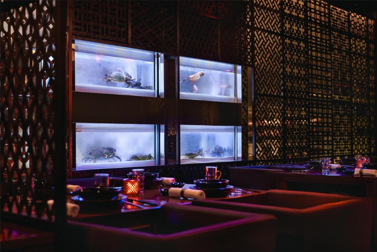 a dining room with two tables and two windows at Grand Hyatt Mumbai Hotel and Residences in Mumbai