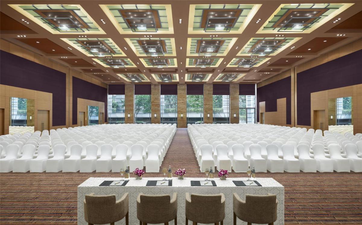 a room with rows of white chairs and tables at Grand Hyatt Mumbai Hotel and Residences in Mumbai