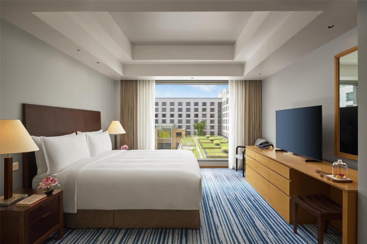 a hotel room with a bed and a large window at Grand Hyatt Mumbai Hotel and Residences in Mumbai