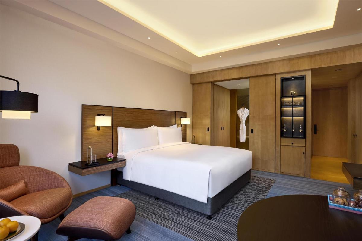 a hotel room with a bed and a chair at Grand Hyatt Mumbai Hotel and Residences in Mumbai