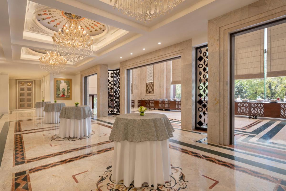 a lobby with two tables and a chandelier at Sheraton New Delhi Hotel in New Delhi a lobby with two tables and a chandelier at Sheraton New Delhi Hotel in New Delhi
