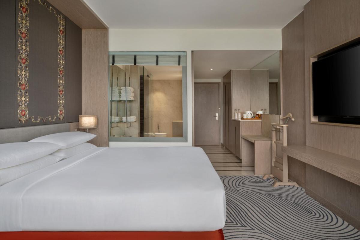 a bedroom with a white bed and a flat screen tv at Sheraton New Delhi Hotel in New Delhi a bedroom with a white bed and a flat screen tv at Sheraton New Delhi Hotel in New Delhi