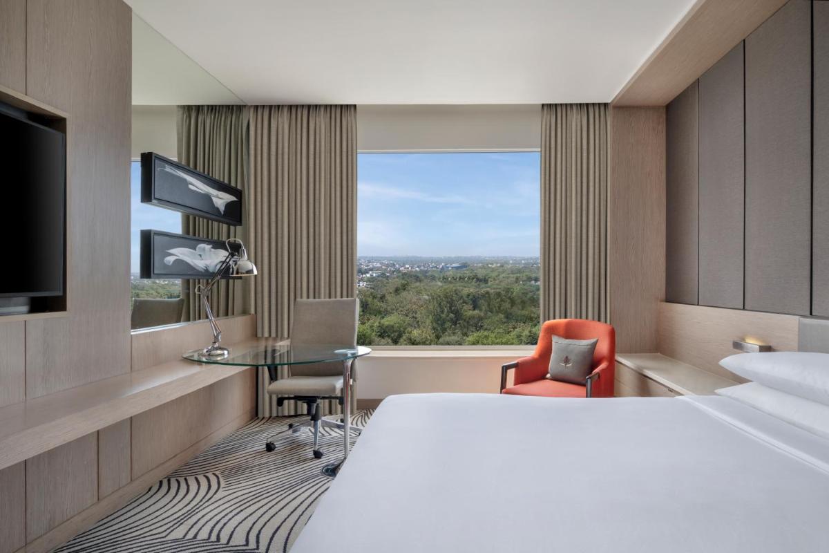 a hotel room with a large bed and a window at Sheraton New Delhi Hotel in New Delhi