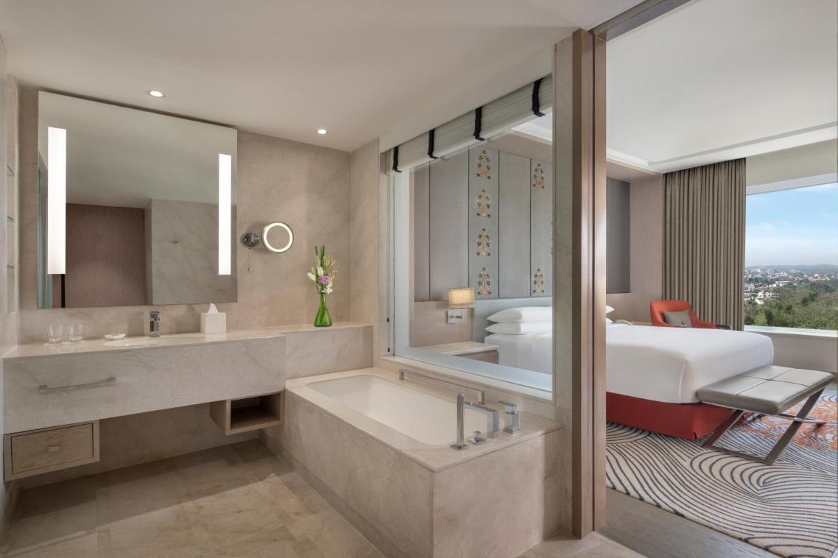 a bathroom with a bed and a tub and a sink at Sheraton New Delhi Hotel in New Delhi a bathroom with a bed and a tub and a sink at Sheraton New Delhi Hotel in New Delhi