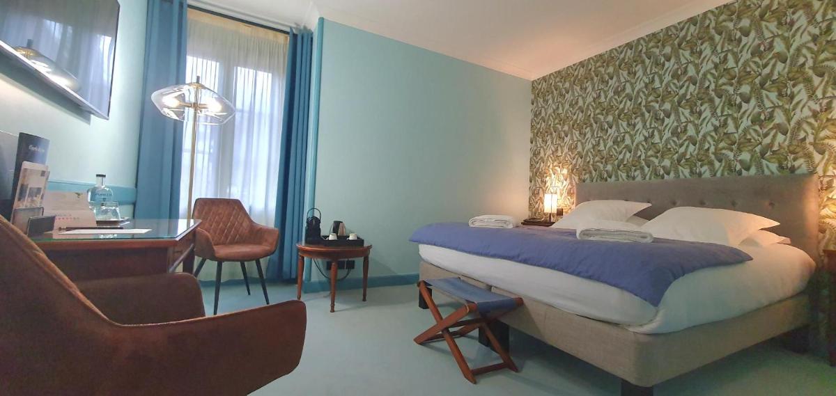 une chambre avec un lit, un bureau et une chaise dans l'établissement Demeures & Châteaux - Hôtel Greuze & Spa Tournus, à Tournus