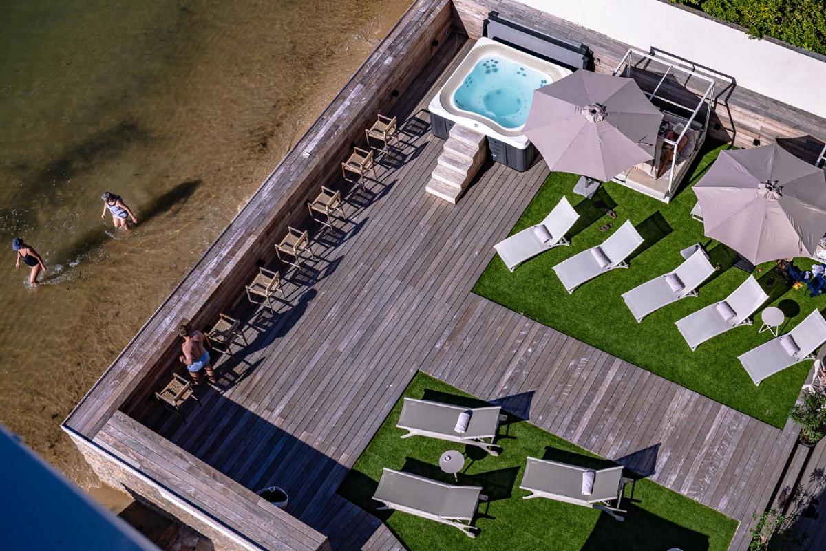 une vue aérienne d'une piscine avec des chaises et des parasols dans l'établissement Les Vagues Hotel & Spa, à Arcachon 22 autres photos