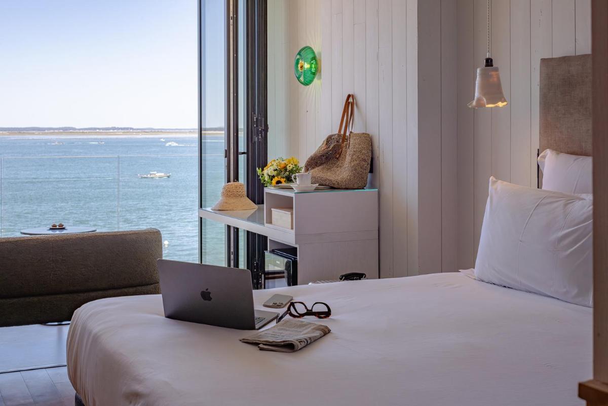 une chambre avec un lit avec un ordinateur portable dessus dans l'établissement Les Vagues Hotel & Spa, à Arcachon