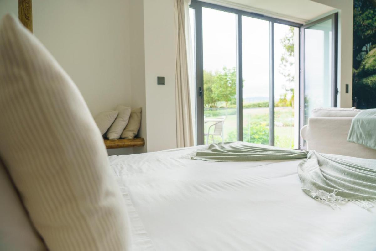 uma cama branca em um quarto com janela em Real Abadia, Congress & Spa Hotel em Alcobaça