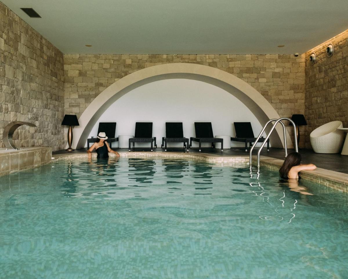 uma mulher está sentada na piscina em Real Abadia, Congress & Spa Hotel em Alcobaça