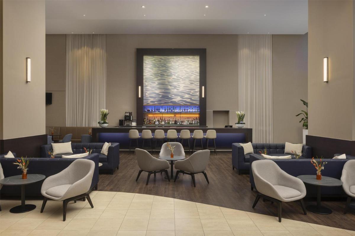 ein Wartezimmer mit Sofas, Tischen und Stühlen in der Unterkunft Hilton Düsseldorf in Düsseldorf