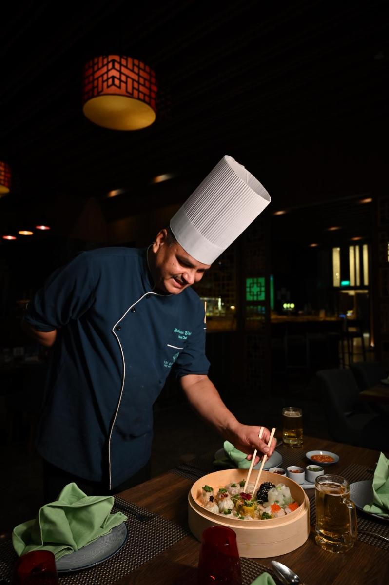 a man in a chefs hat preparing a plate of food at Holiday Inn New Delhi Mayur Vihar Noida by IHG in New Delhi a man in a chefs hat preparing a plate of food at Holiday Inn New Delhi Mayur Vihar Noida by IHG in New Delhi