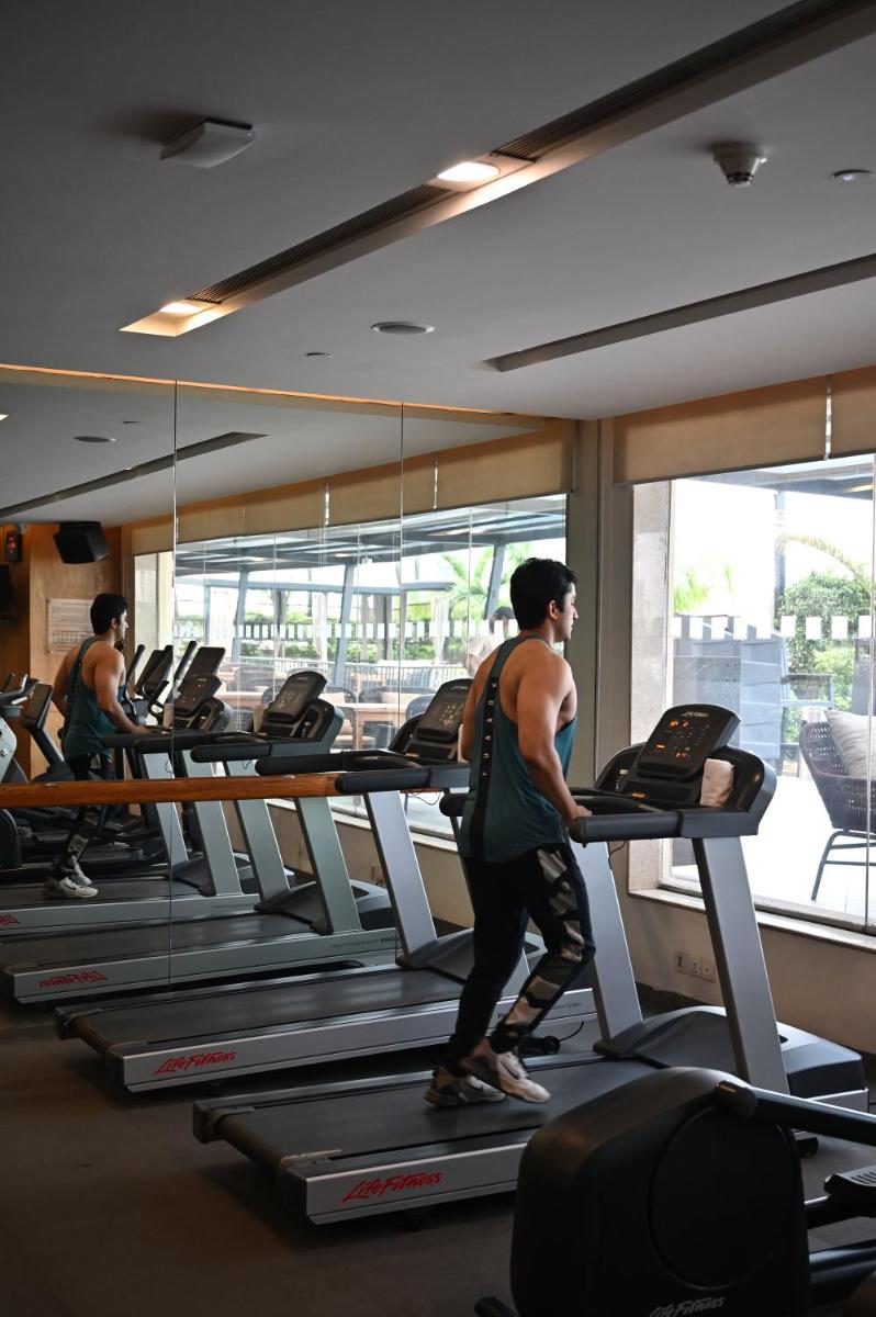 a man walking on a treadmill in a gym at Holiday Inn New Delhi Mayur Vihar Noida by IHG in New Delhi a man walking on a treadmill in a gym at Holiday Inn New Delhi Mayur Vihar Noida by IHG in New Delhi