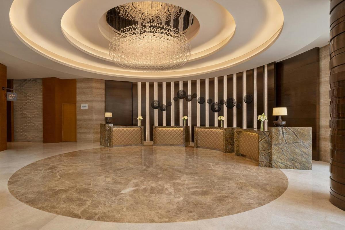 a large lobby with a chandelier and a large ball at Bengaluru Marriott Hotel Whitefield in Bengaluru