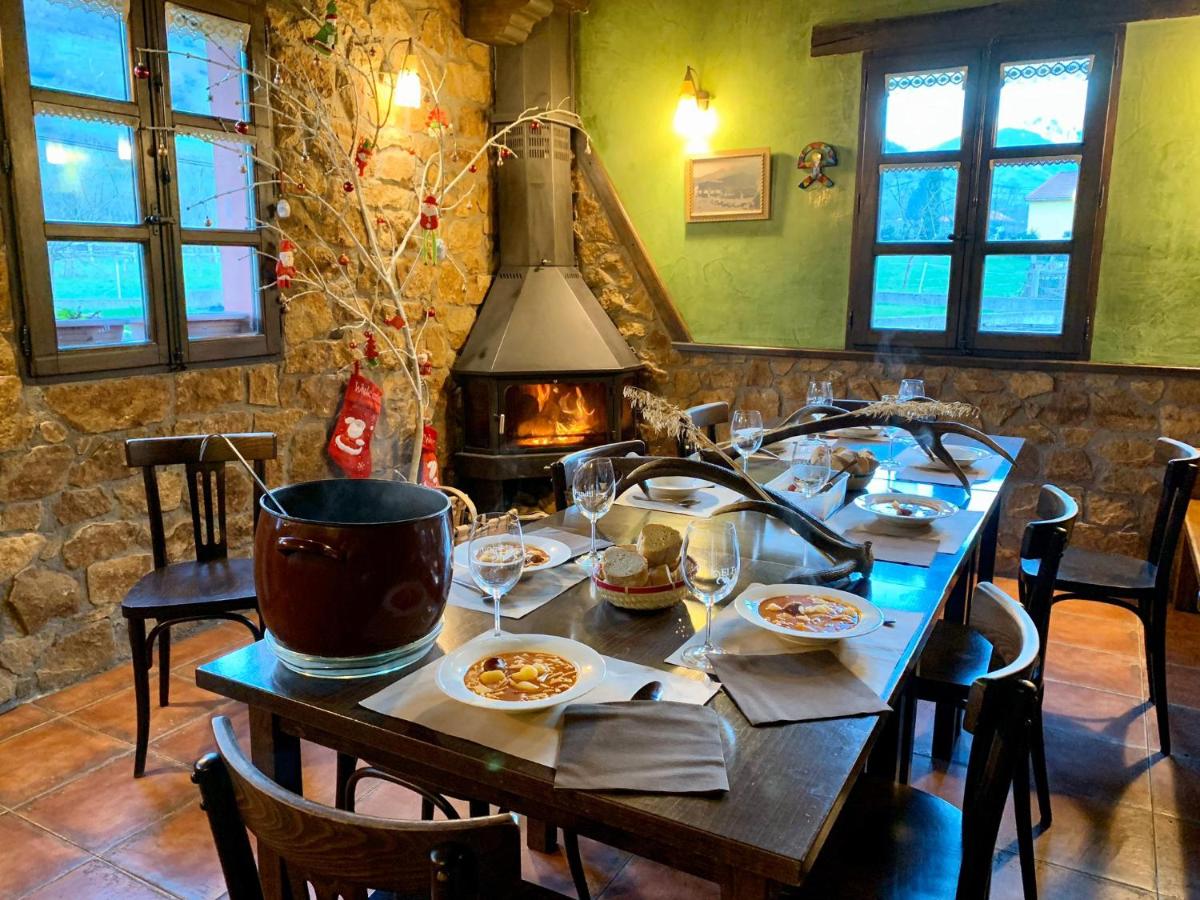 una mesa con platos de comida y una chimenea en Hotel Rural El Fundil, en El Pino