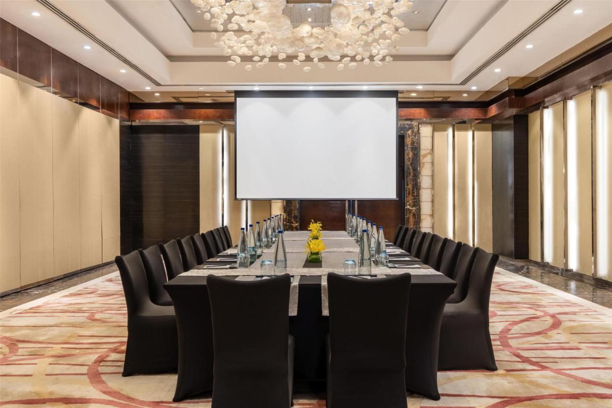 a conference room with a long table and chairs at Radisson Blu Plaza Delhi Airport in New Delhi a conference room with a long table and chairs at Radisson Blu Plaza Delhi Airport in New Delhi