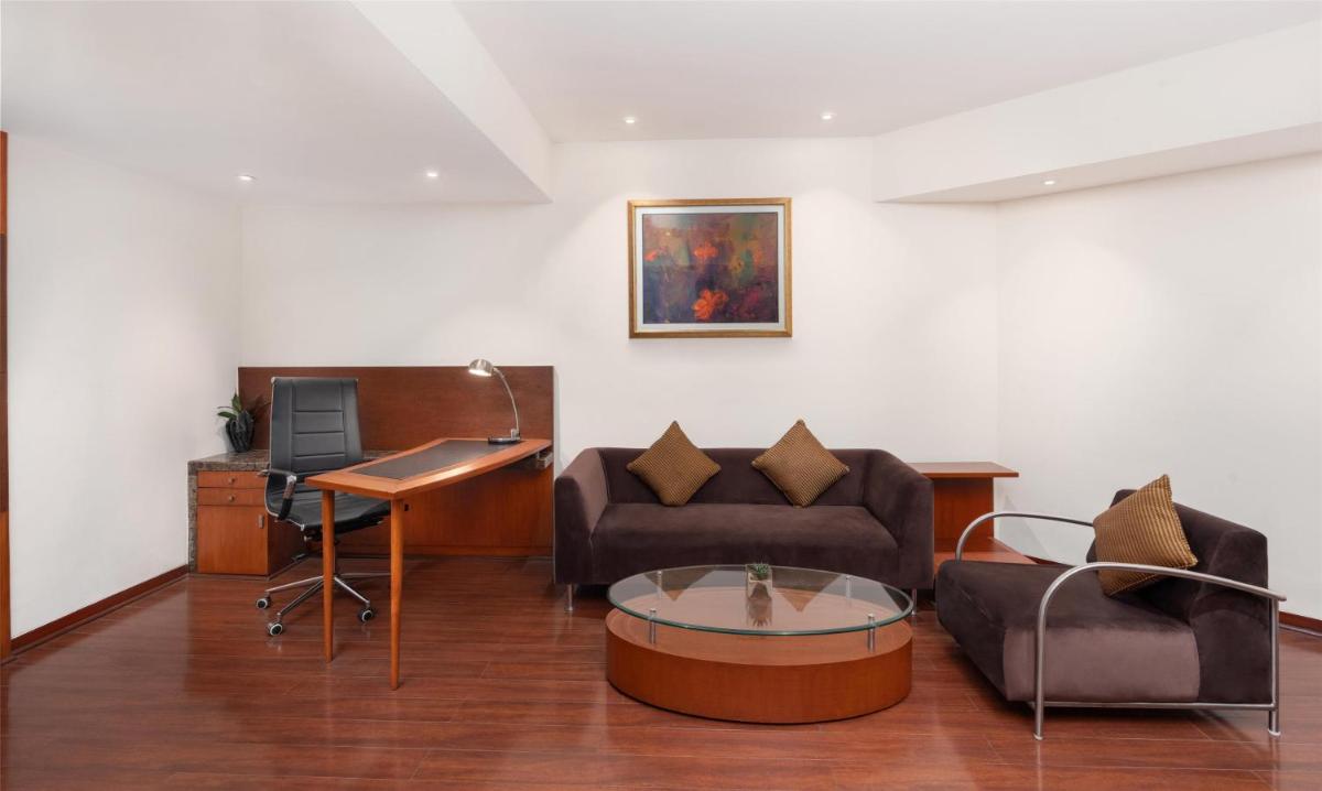a living room with a couch and a table at Radisson Blu Plaza Delhi Airport in New Delhi a living room with a couch and a table at Radisson Blu Plaza Delhi Airport in New Delhi