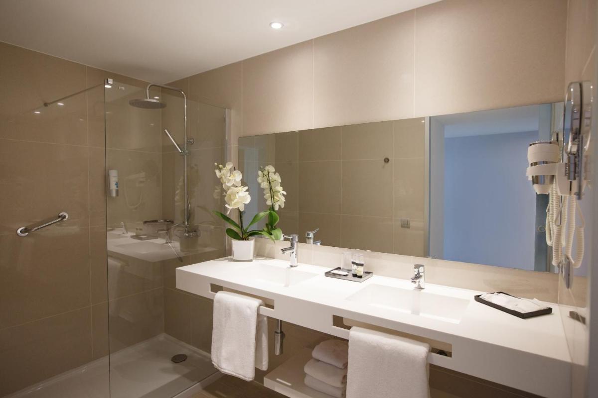 Un baño con lavabo, ducha y espejo. en Santa Monica Suites Hotel, en Playa del Inglés