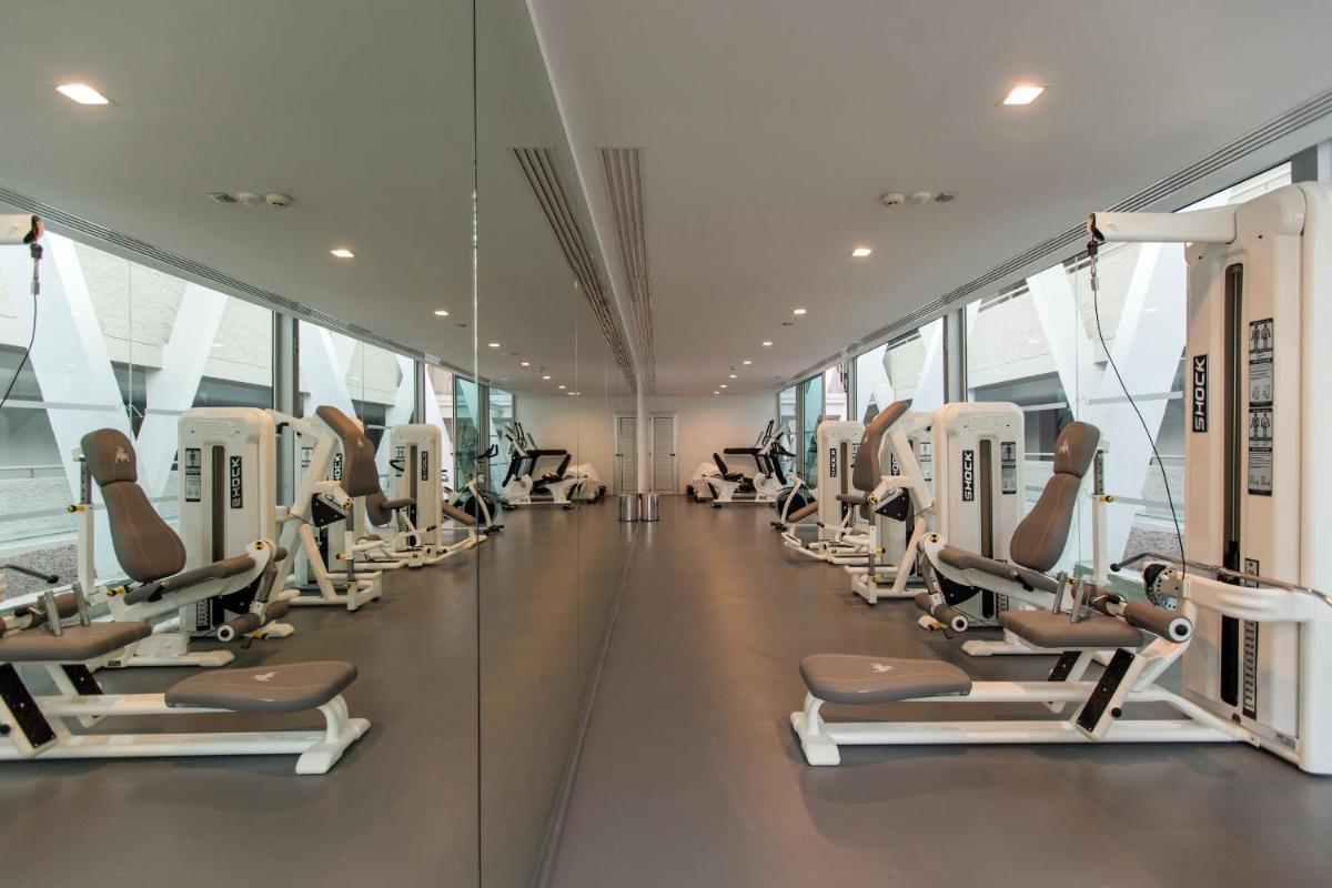 un gimnasio con una fila de máquinas de entrenamiento y pilates en Santa Monica Suites Hotel, en Playa del Inglés