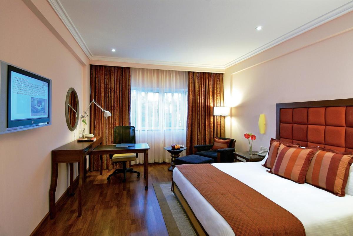 a hotel room with a bed and a desk at Vivanta Bengaluru Residency Road in Bengaluru a hotel room with a bed and a desk at Vivanta Bengaluru Residency Road in Bengaluru