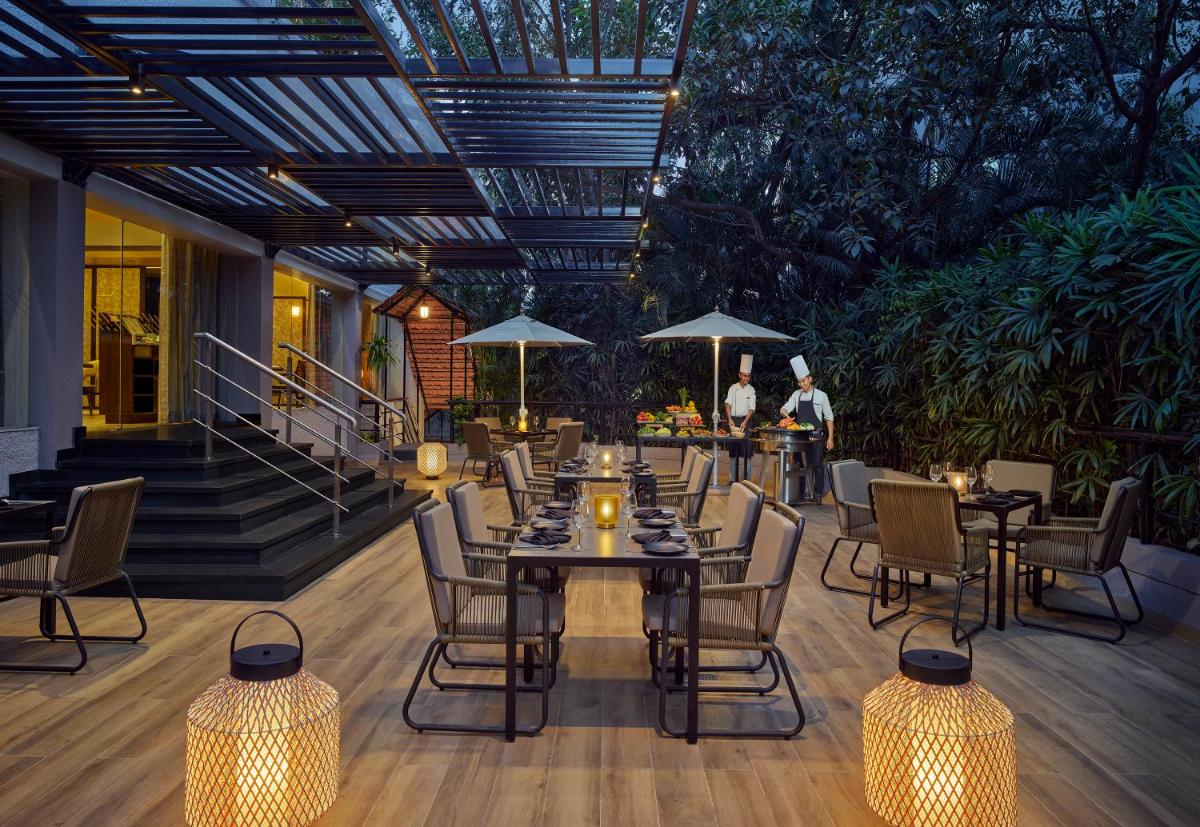 a patio with a table and chairs and lights at Vivanta Bengaluru Residency Road in Bengaluru a patio with a table and chairs and lights at Vivanta Bengaluru Residency Road in Bengaluru