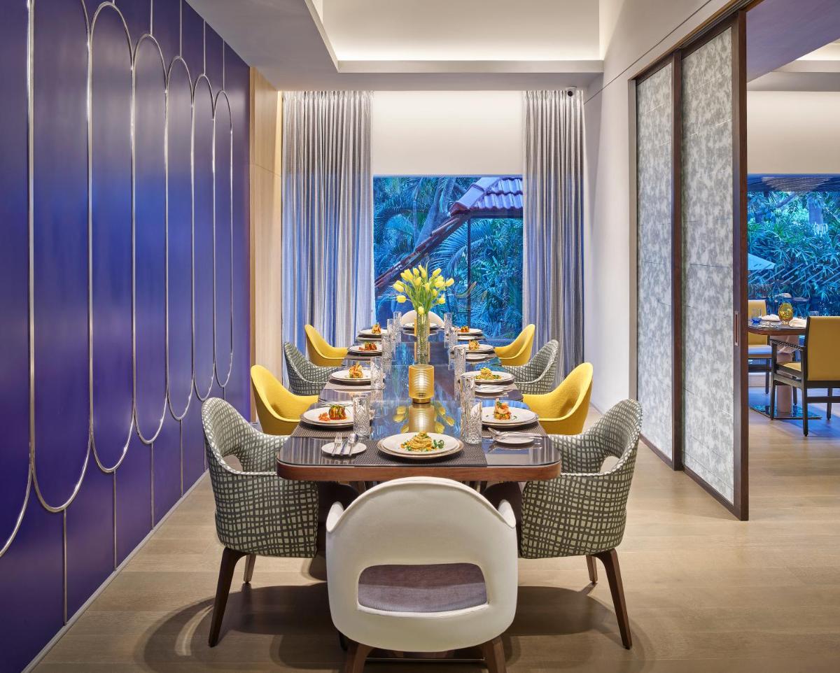 a dining room with a long table and chairs at Vivanta Bengaluru Residency Road in Bengaluru a dining room with a long table and chairs at Vivanta Bengaluru Residency Road in Bengaluru