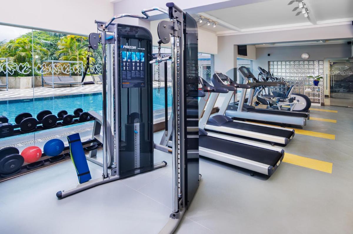 a gym with cardio equipment and a swimming pool at Vivanta Bengaluru Residency Road in Bengaluru a gym with cardio equipment and a swimming pool at Vivanta Bengaluru Residency Road in Bengaluru