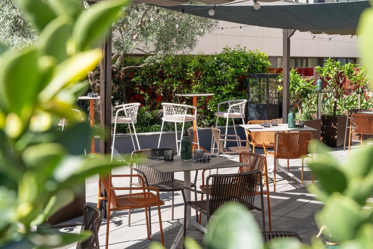 Un patio con mesas y sillas y una sombrilla. en Catalonia Ramblas 4* Sup, en Barcelona 55 fotos más