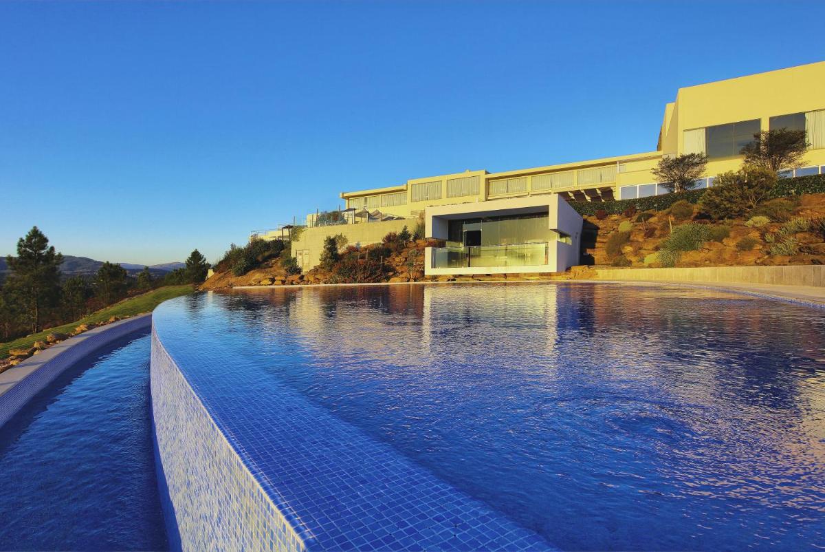 uma piscina em frente a um prédio em Agua Hotels Mondim de Basto em Mondim de Basto uma piscina em frente a um prédio em Agua Hotels Mondim de Basto em Mondim de Basto