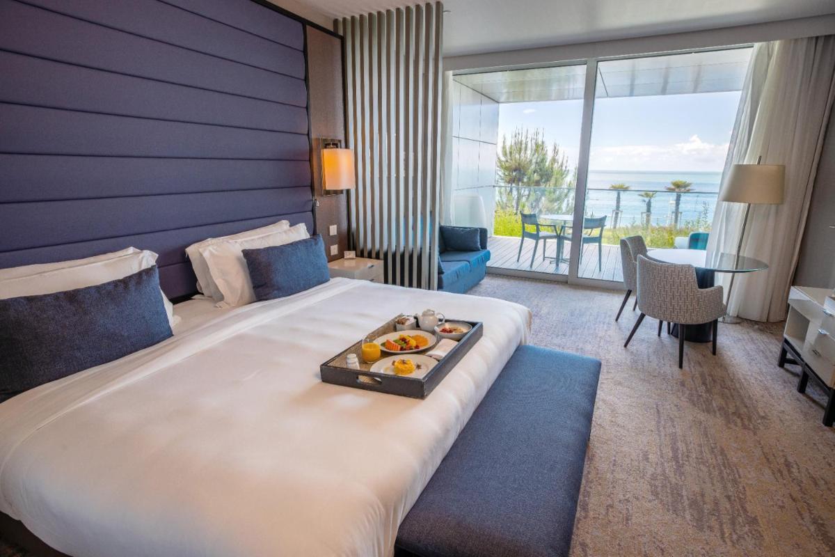 um quarto de hotel com uma cama com uma bandeja de comida em cima em InterContinental Cascais-Estoril by IHG em Estoril