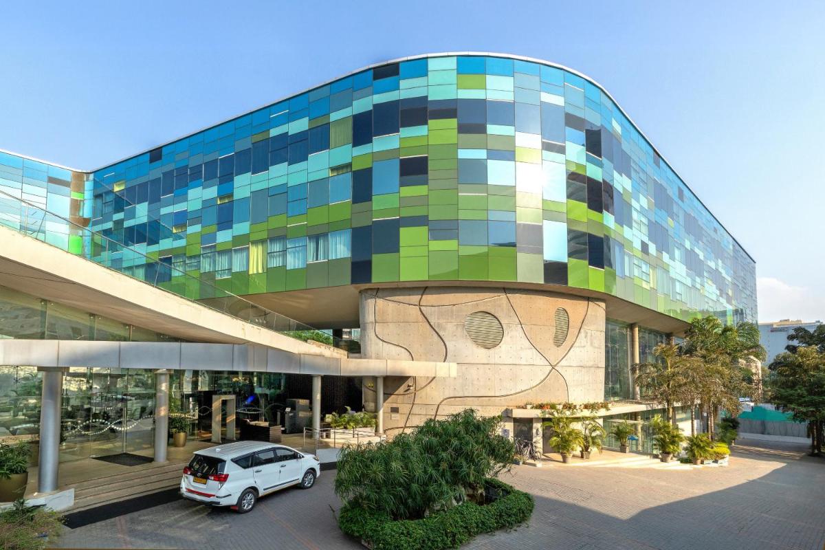 a car parked in a parking lot in front of a building at Vivanta Bengaluru, Whitefield in Bengaluru