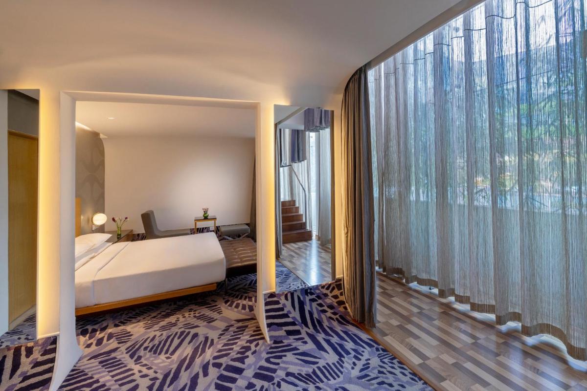 a bedroom with a bed and a large window at Vivanta Bengaluru, Whitefield in Bengaluru a bedroom with a bed and a large window at Vivanta Bengaluru, Whitefield in Bengaluru