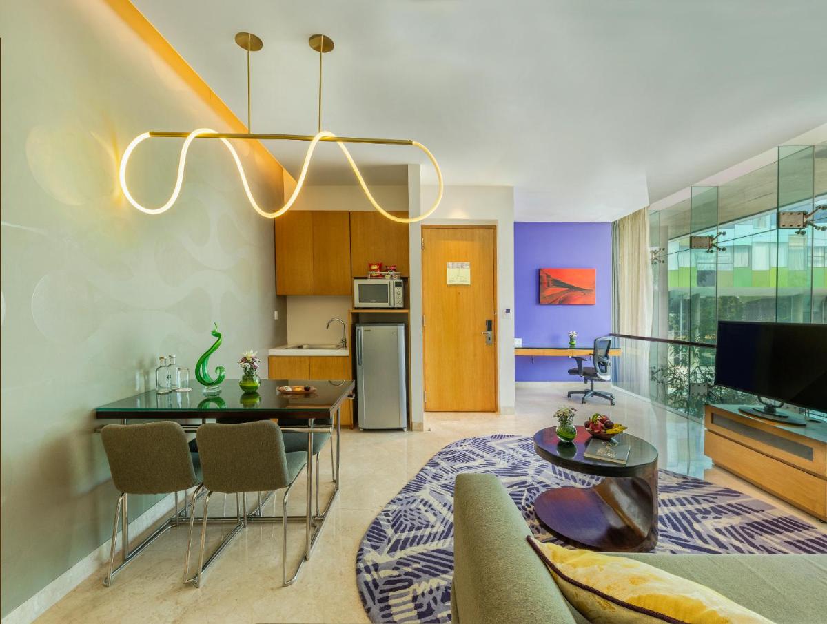 a kitchen and living room with a table and chairs at Vivanta Bengaluru, Whitefield in Bengaluru