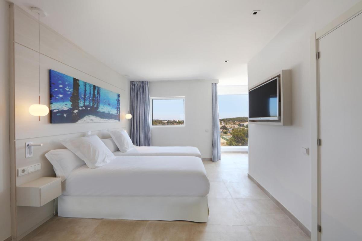 Una televisión o centro de entretenimiento en Iberostar Selection Santa Eulalia Adults-Only Ibiza