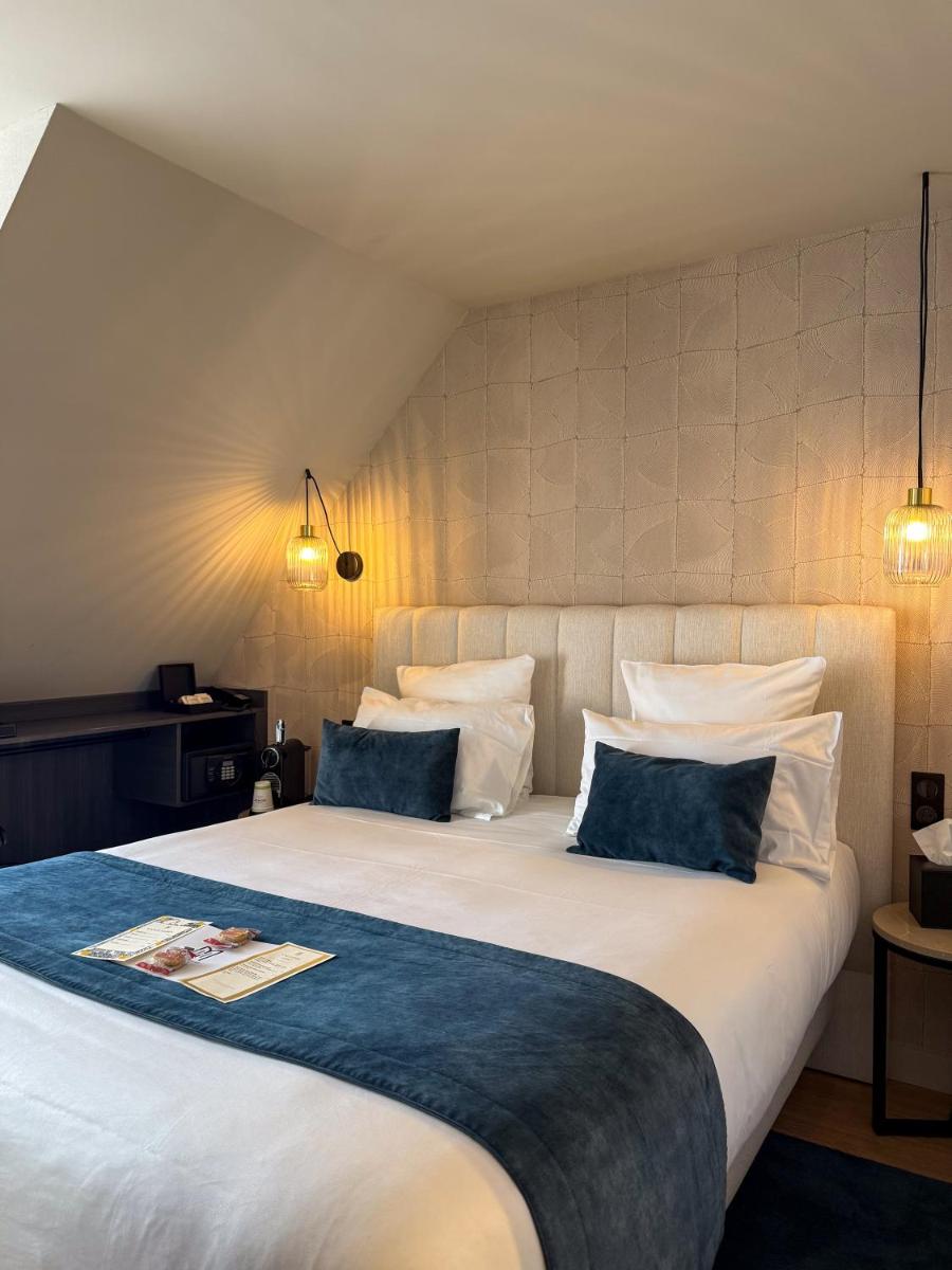 une chambre avec un grand lit blanc avec deux oreillers dans l'établissement Hôtel & Spa Le Maury, Vannes, The Originals Boutique, à Vannes